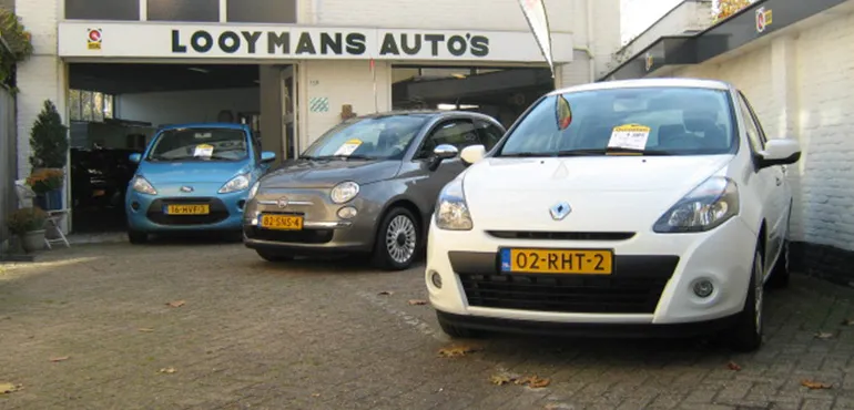 De gevel met het bord Looymans Auto's en drie occasions op de oprit